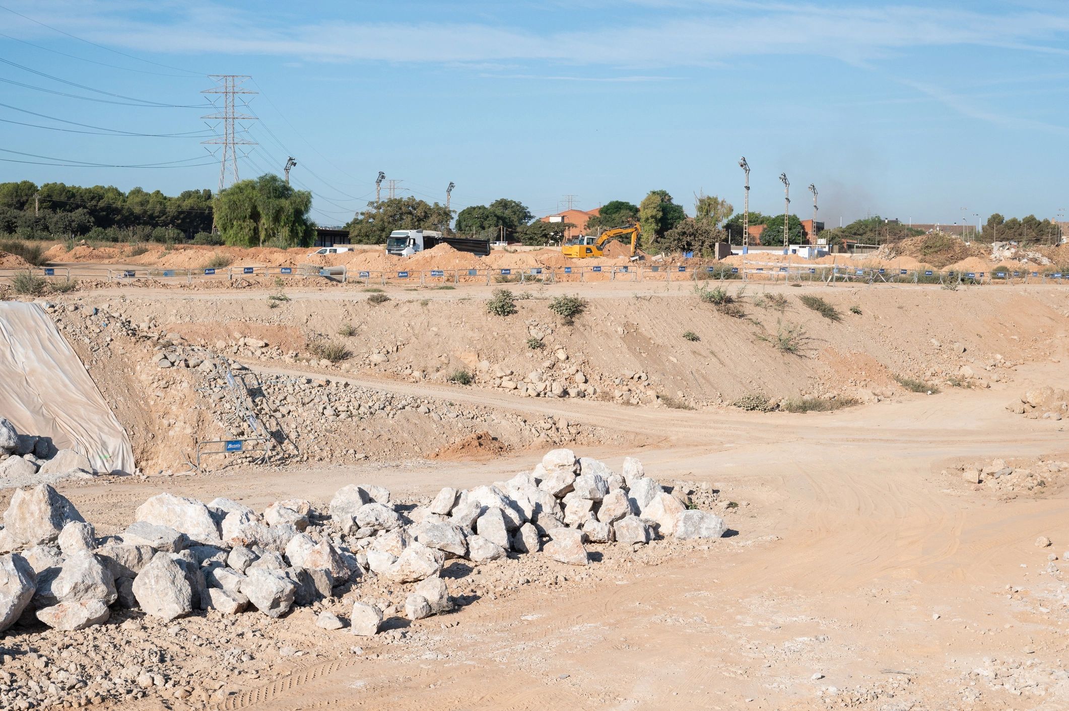 Excavator performing earthmoving work on a large construction site.